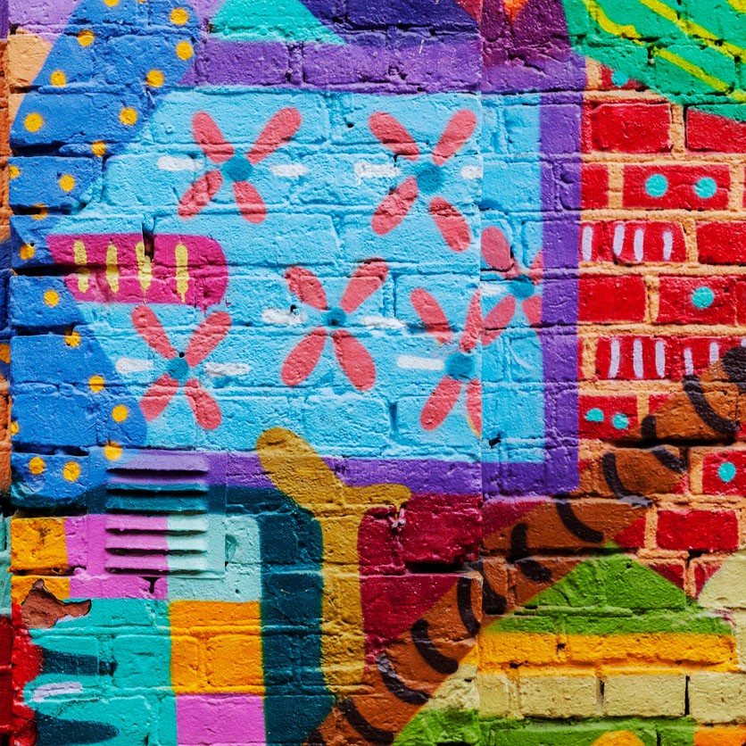 Colorful red yellow and blue graffiti on a brick wall.